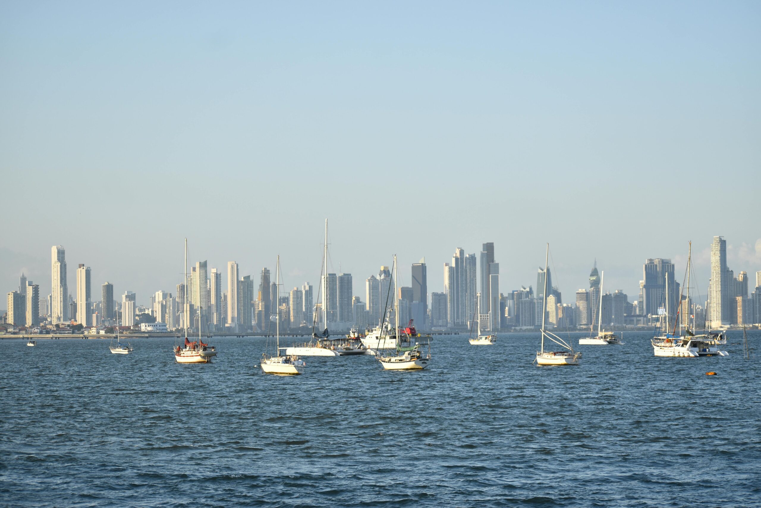 Scenic view of Panama City skyline with sailboats on the calm sea at daytime.